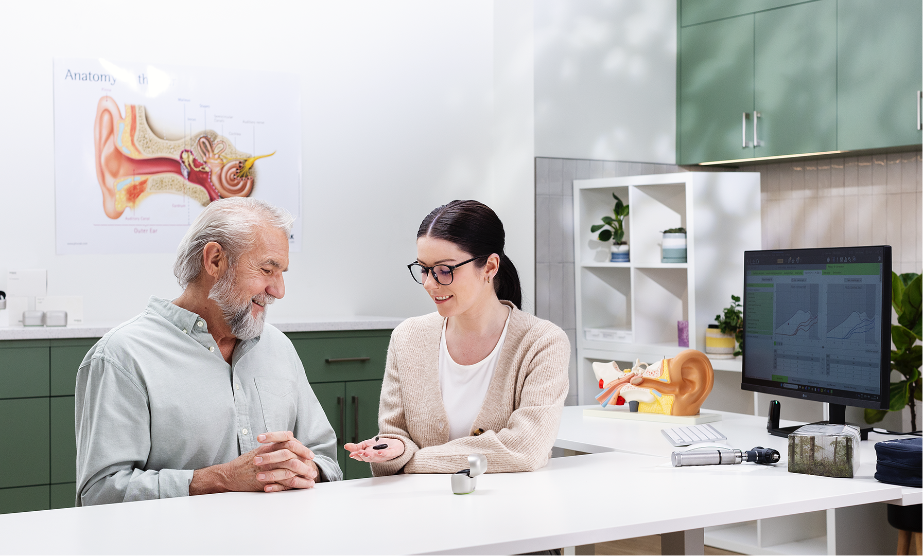 Mitarbeiter mit Kunden in der Anpassung_Hörgeräte_neuhaus_hören+sehen